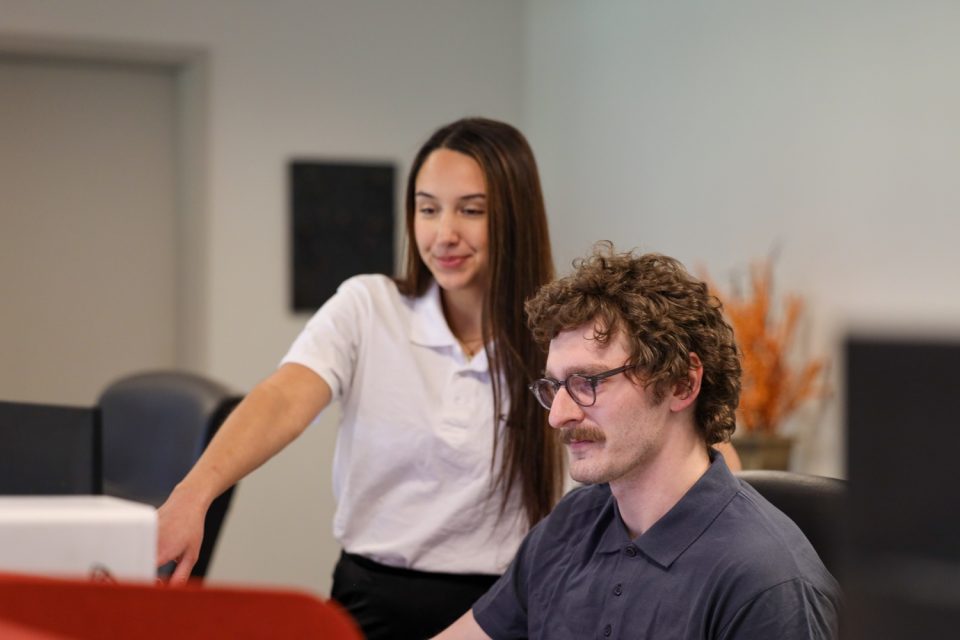 Two team members working a location map on screen